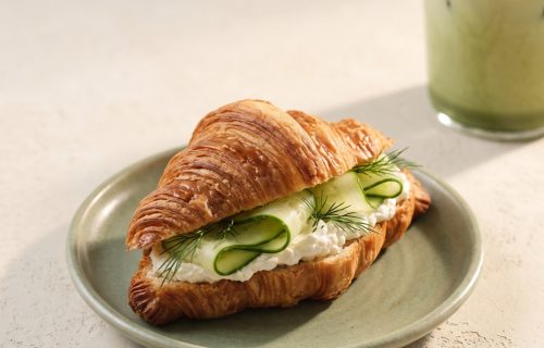 Croissant mit Frischkäse neben Iced Matcha